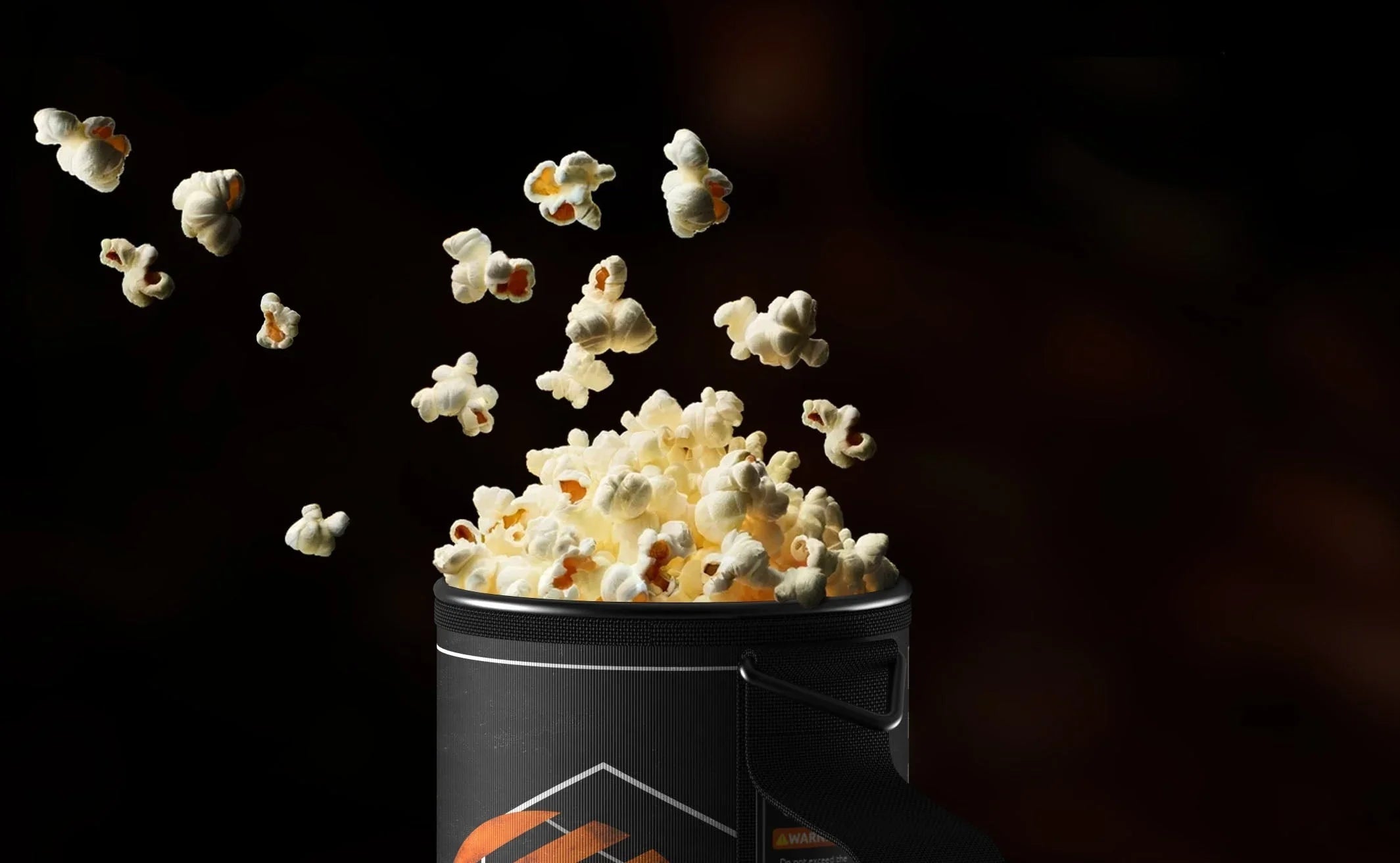 Stoke Voltaics kettle pot filled with freshly popped popcorn against a dark background